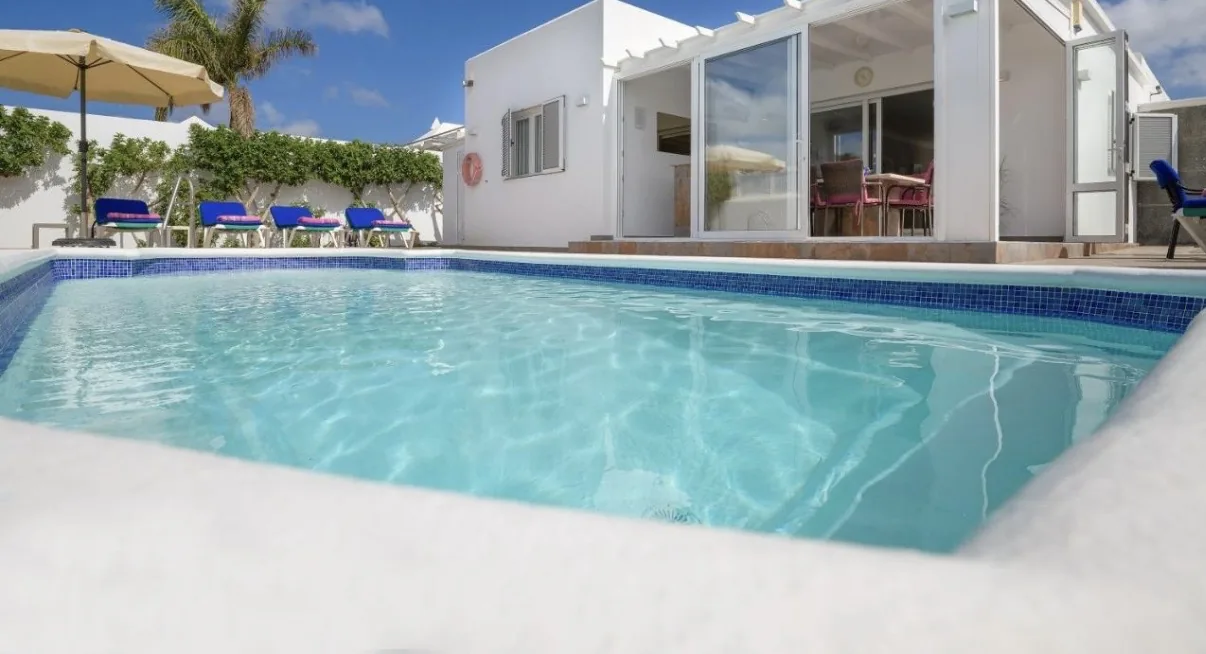 Pool mit Sonnenliegen und Sonnenschirm